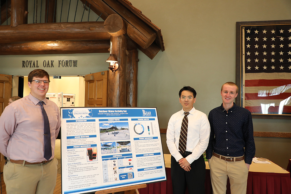 group of students smiling by poster board