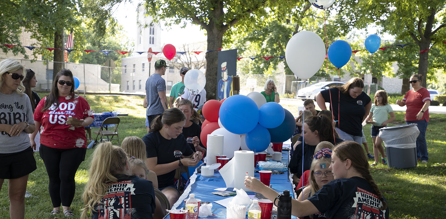 Kids gather around a table for face painting.